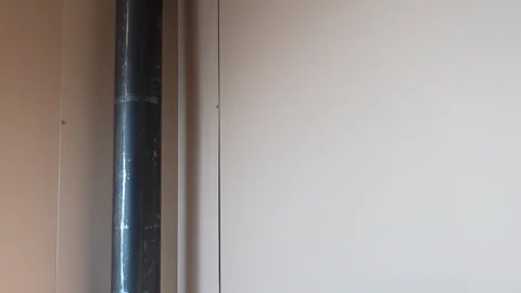 Black pipe running along beige wall in a minimalistic interior Stock Footage 276341794