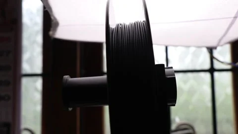 Black PLA filament on a roll attached to 3d printer under studio light Video stock 162623985