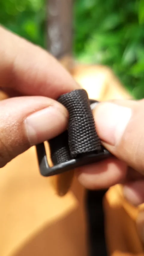 Black plastic backpack strap buckle, hands adjusting adjustable webbing str.. Stock Footage 342628609