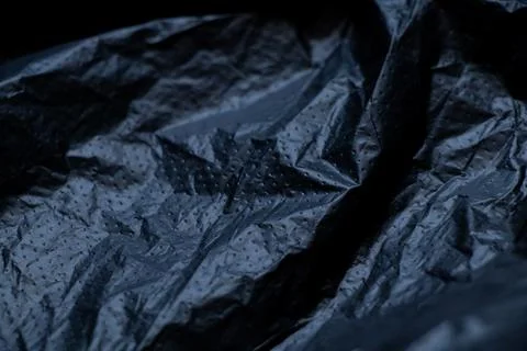 Black plastic bag as a background in the dark Stock Photos