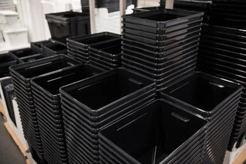 Black plastic box containers in row at store Stock Photos