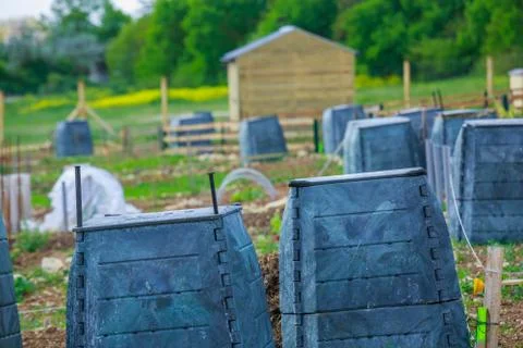 Black plastic compost bin and small wooden cabin in town garden Stock Photos