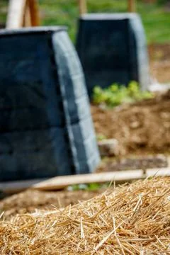 Black plastic compost bin and small wooden cabin in town garden Stock Photos