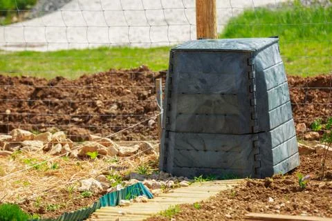 Black plastic compost bin in town garden Stock Photos