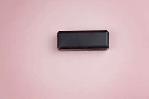 Black plastic container of rectangular shape on a pink background 写真素材