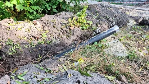Black Plastic Drainage Pipe Installation in a Garden Trench for Water 動画素材 347662963