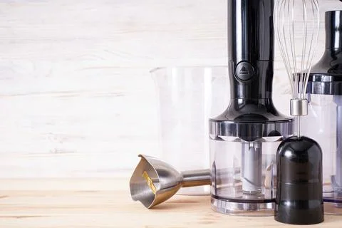 Black plastic electrical hand blender and accessory on the wooden background, Foto stock