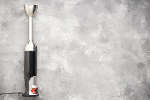 Black plastic electrical hand blender with stainless steel body on the gray b Foto stock
