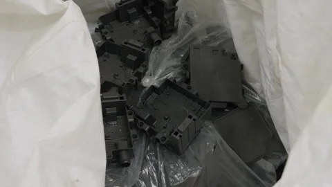 Black plastic electronic housings in recycling bag Stock Footage 334285885
