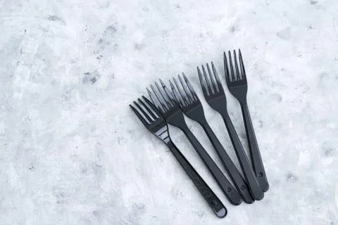 Black plastic forks on a gray background Stock Photos
