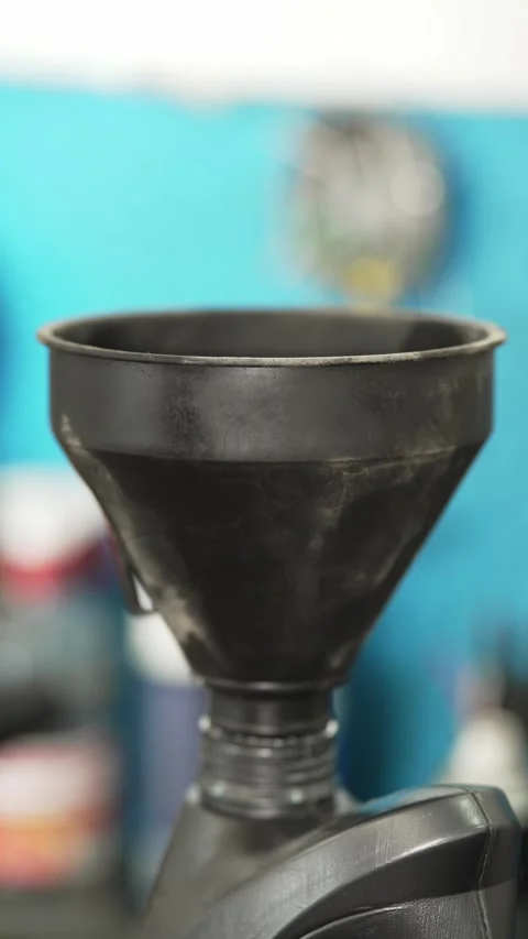 Black plastic funnel placed on a bottle inside auto workshop. Stock Footage 341485370