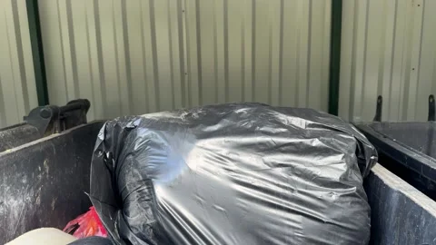 Black plastic garbage bag in metal dumpster, waste disposal  Video stock 344041305