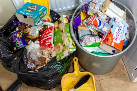 Black plastic garbage bag overflowing with rubbish Stock Photos
