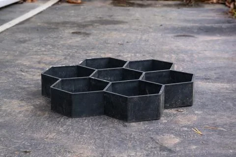 Black plastic mold for making hexagonal paving tiles. DIY garden path project Stock Photos