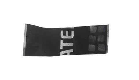 Black plastic packaging strip with printed letters and subtle texture. Irre.. Stock Photos