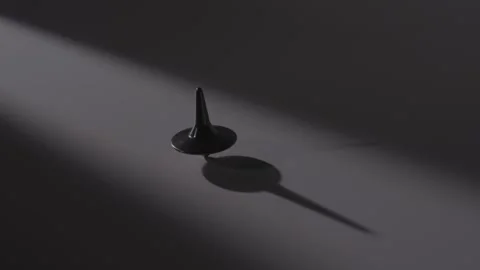 Black Plastic Spinner Toy Rotating Under Dramatic Spotlight Shadow Vídeos de archivo 336550364