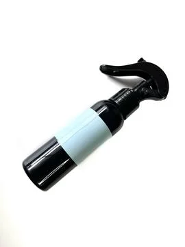 Black plastic spray bottle with a light blue label Stock Photos