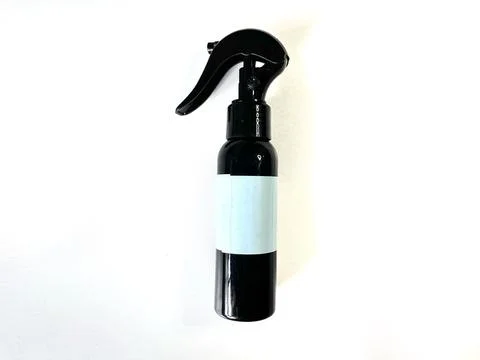 Black plastic spray bottle with a light blue label Stock Photos