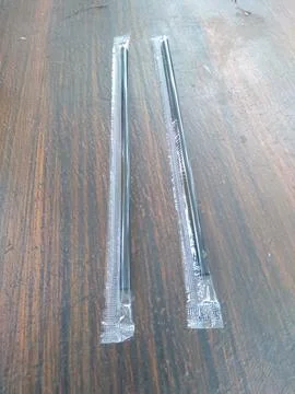 Black plastic straws Foto stock