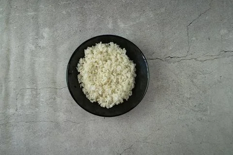 Black plate with cooked rice on the table Stock Photos