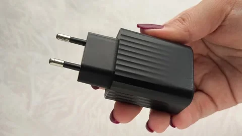 The black plug of the phone charging cable in a womans hand. Phone charging Video stock 317668913