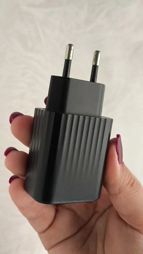 The black plug of the phone charging cable in a womans hand. Phone charging Stock Footage 317669061