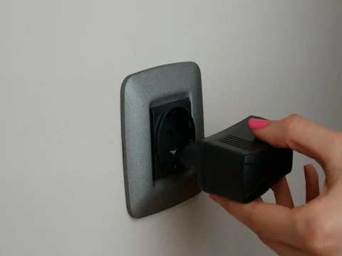 Black plug putting into a wall socket Stock Footage 72274179