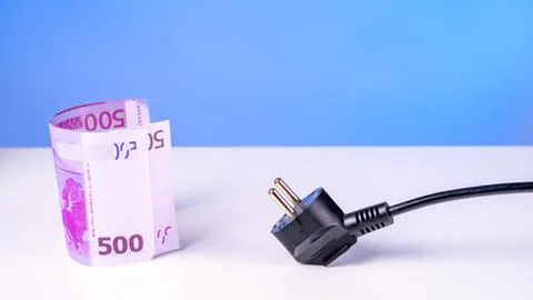 A black plug is on a table next to a pink bill Foto stock