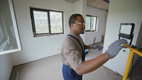 Black Plumber Working on Home Renovation in Unfinished Room Stock Footage 340615185