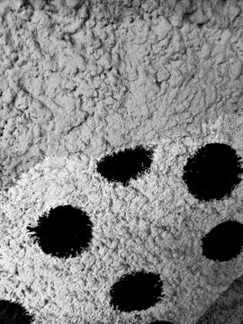 Black Polka Dots Painted on Rough Stucco Wall Texture Stock Photos