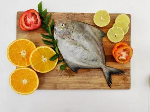 Black Pomfret Decorated with Vegetables and Herbs. Stock Photos