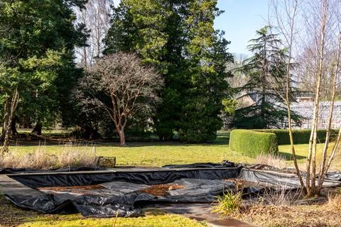 Black pond liner installed in rectangular garden pond during landscaping Fotos Stock