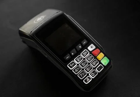 Black POS terminal on a dark table. Stock Photos