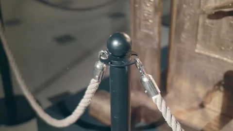 Black posts and thick ropes on carabiners are mobile fencing in museums Stock Footage 323839936