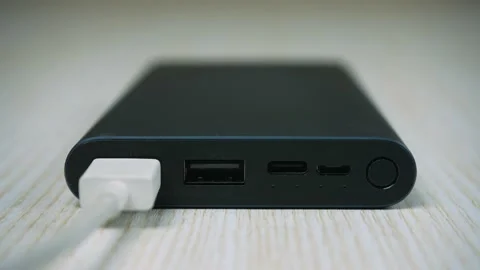 Black power bank in process of charging. Four little indicator lights blinking Video stock 235622236