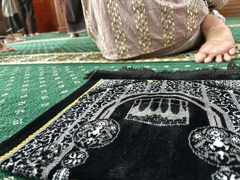 Black prayer mat inside a mosque Stock Photos