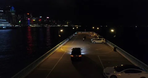 Black presentable expensive car parks on the coast overlooking the skyscrapers Video stock 146754391