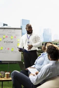 Black presenter explaining strategy roadmap with clipboard in hand Stock Photos