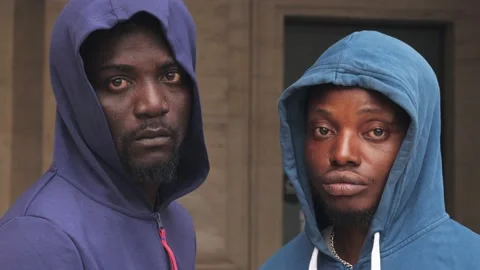 Black pride. Two serious young African men stare at the camera - change of focus Stock Footage 218761746