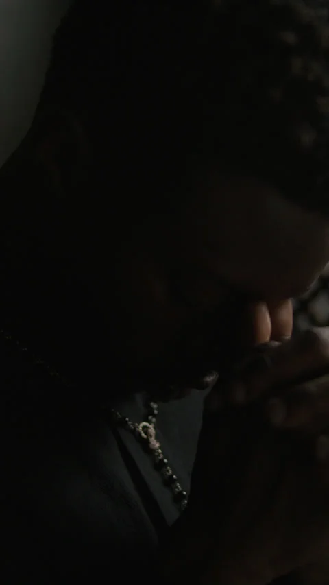 Black Priest Bowing Head in Deep Prayer inside Confessional Booth Stock Footage 318340694