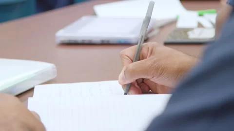 Black prisoner hand writing on notebook in prison Stock Footage 339089637