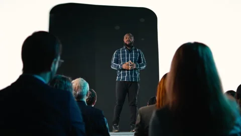 Black product manager introducing new mobile phone product at conference hall Stock Footage 328056294