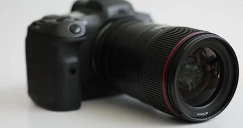 Black professional photo camera spinning on white background closeup 4k movie Stock Footage 241893680