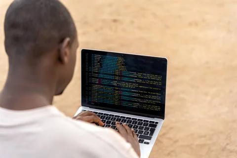 Black programmer coding on beach Stock Photos
