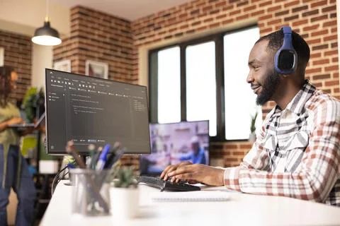 Black programmer happily reviewing software code on computer 스톡 사진