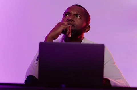 A black programmer works using a laptop computer. the man works at night. Foto stock