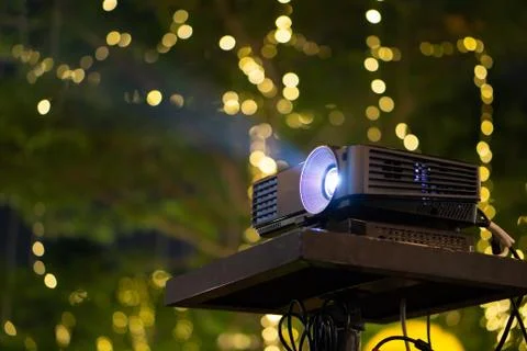 Black Projector on stand table ready for presentation in yellow bokeh backgro Stock-Fotos