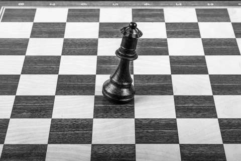 Black queen falling on the chessboard Stock Photos