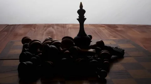 The black queen stands on a chessboard, surrounded by the rest of the pieces. Bo Stock Footage 233031324