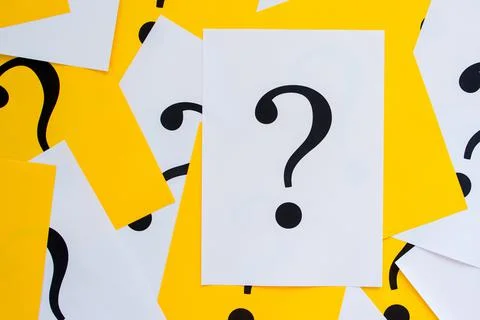 Black question marks on the colored papers Stock Photos